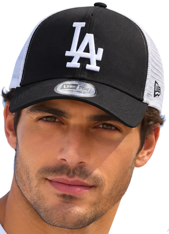 A man and a woman wearing matching black and white Los Angeles Dodgers trucker hats with New Era branding, set against a clear blue sky.
