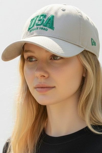 Person wearing a beige cap with 'USA' text on a light background