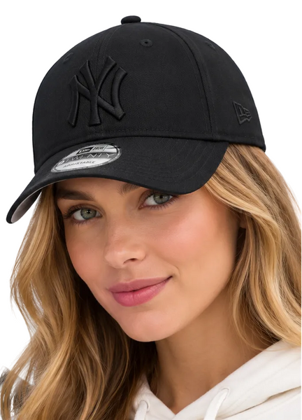 Two models wearing black New Era 9FIFTY baseball caps with an embossed New York Yankees logo, set against a bright blue sky background.