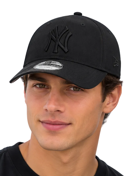 Two models wearing black New Era 9FIFTY baseball caps with an embossed New York Yankees logo, set against a bright blue sky background.