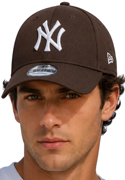 A man and a woman wearing dark brown New Era 9FORTY baseball caps with a white New York Yankees logo, set against a bright blue sky background.
