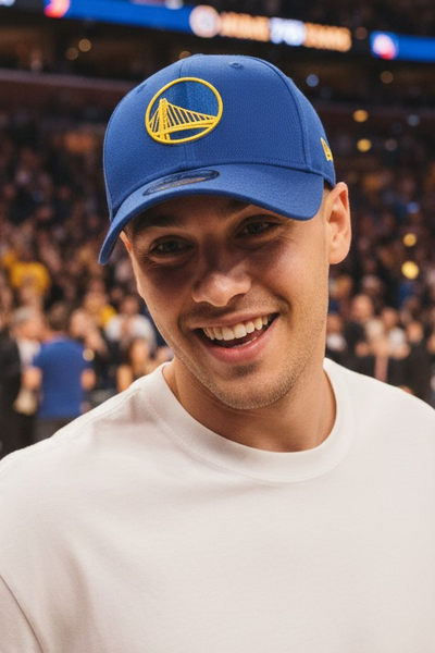 Person wearing a blue golde_state_warriors cap with a logo at a sports event