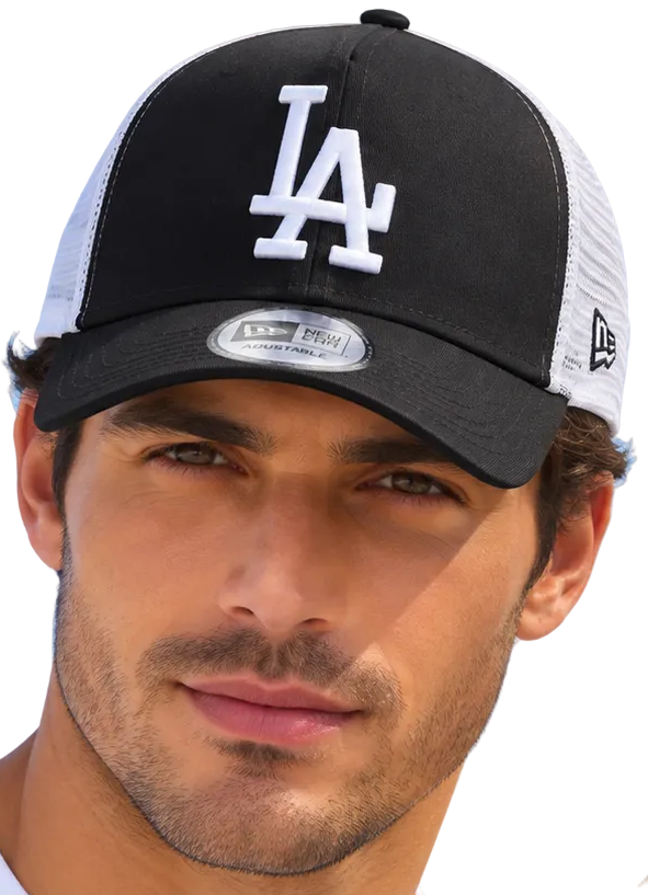 A man and a woman wearing matching black and white Los Angeles Dodgers trucker hats with New Era branding, set against a clear blue sky.