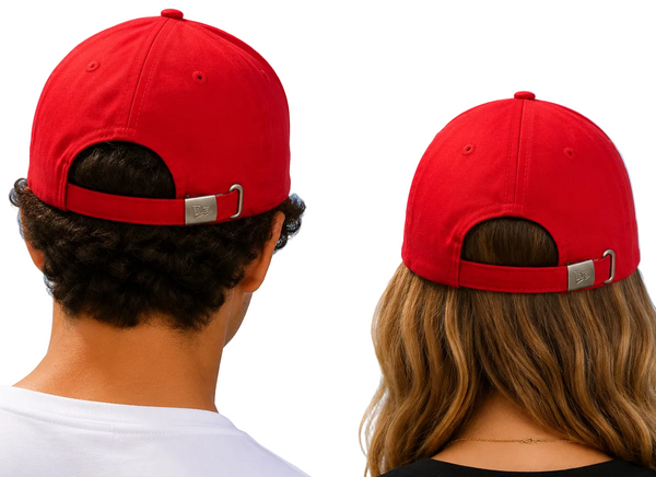 Two people shown from behind wearing matching bright red baseball caps with adjustable back straps and silver metal hardware, set against a clear blue sky.